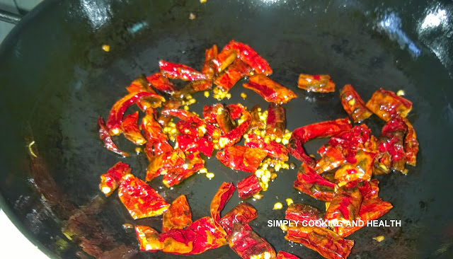 Dry red chili is frying in a non stick wok