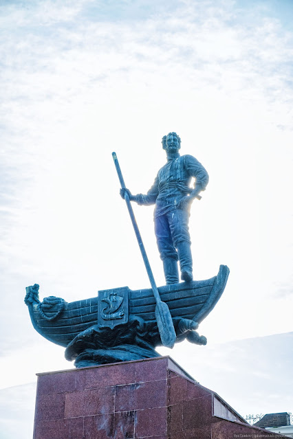 Скульптура мужчины в лодке с веслом