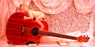 Wallpaper bayi lucu tidur di atas gitar