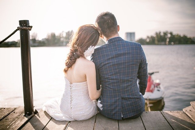 Lovers sit on the bridge near the river. They feeling love and exchanging pleasure energy.