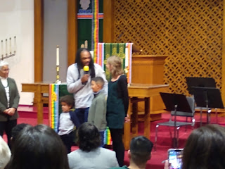 man, woman, and two children in front of church