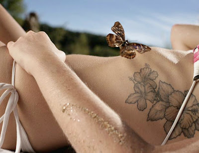Flowers tattoo on a woman's body side wearing a bikini