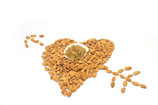 a pile of almonds arranged into the shape of a heart with an arrow through it 