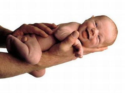 Pequeno bebê risonho cabe na palma da mão.