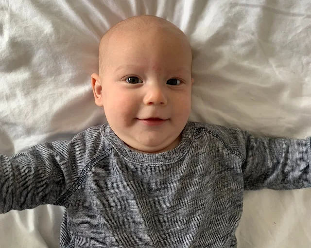 Baby Boy on a white sheet looking at the camera