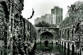 A boy jumping into the Black waters of the Baoli