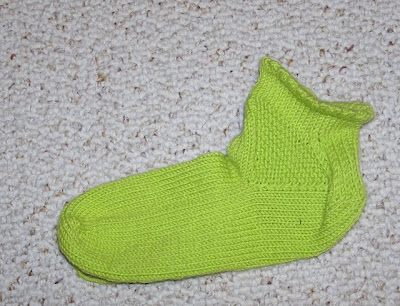 a green ankle sock with a garter-stitch triangle gusset