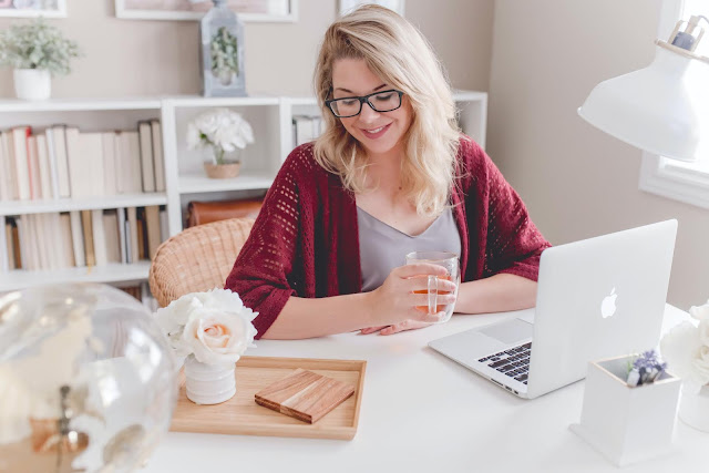 blonde woman working on her laptop with cup of tea