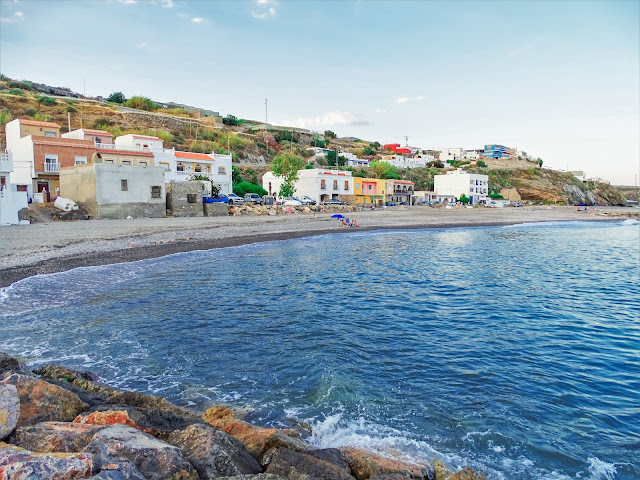 Pequeña playa con un poblado a su espalda