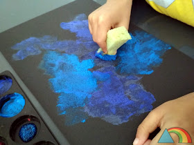 Pintura de tonos azules aplicada sobre cartulina negra con esponja