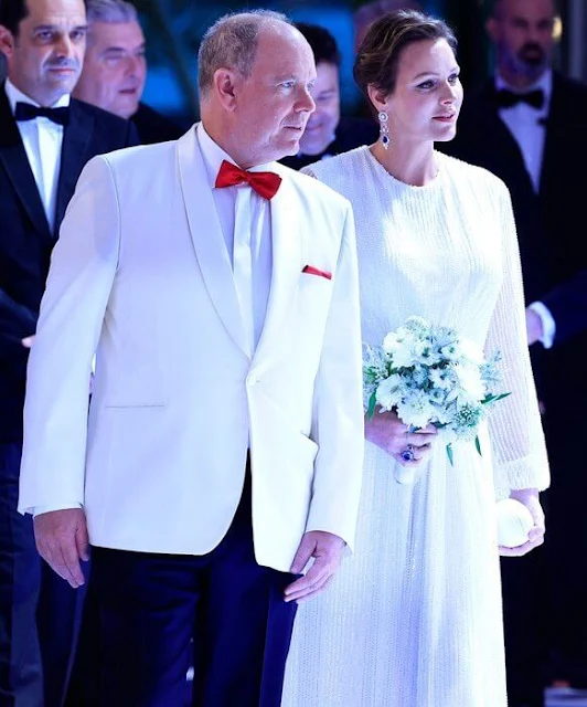 Princess Charlene wore an ivory gown by Akris. Diamond earrings. Camille Gottlieb wore a blue cape gown by Zuhair Murad