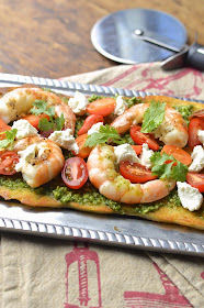 Bake pre-made pizza dough to make the perfect flatbread with grilled shrimp, cilantro pesto and goat cheese.