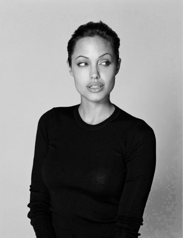 Black and white photograph of woman with full lips and hair up in a bun wearing a black crewneck long sleeve t-shirt