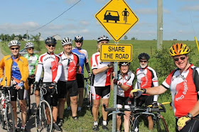 image Kawartha Cycling Club June Share the Road Campaign Kick-Off shows cycists with bicycles around a newly erected Share the Road sign