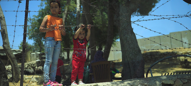 Dos niños frente a un cercado de alambre en la aldea palestina de Al-Walaja, en Cisjordania. UNRWA/Marwan Baghdadi