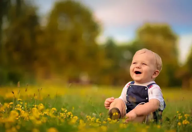 A baby on a green flower yard