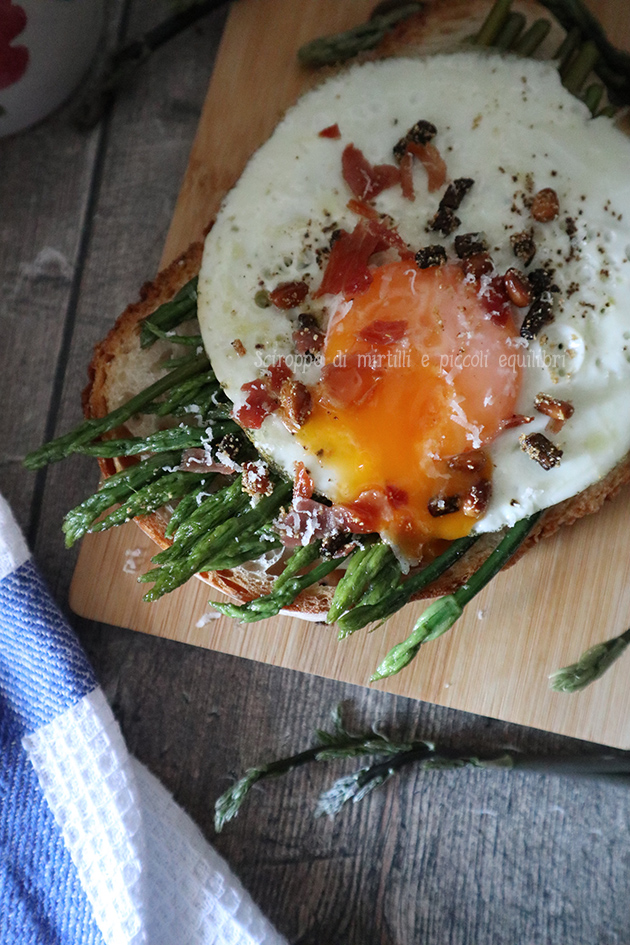 Bruschetta con asparagi selvatici, uovo, briciole di prosciutto crudo e pinoli croccanti