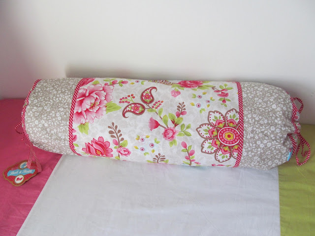 long round bright floral pillow with tag attached