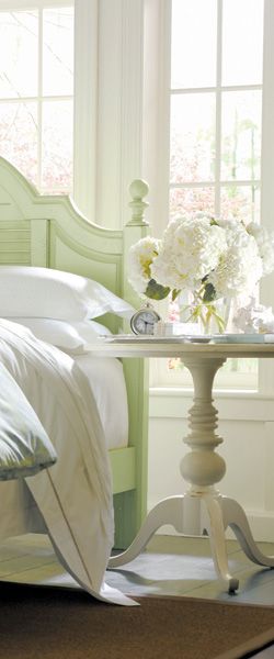 mint green wooden bed, white walls