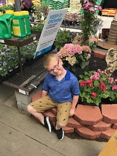 Noah waiting patiently by the flowers at the garden center 