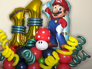 Bunte Ballondekoration mit Folienballon Super Mario.