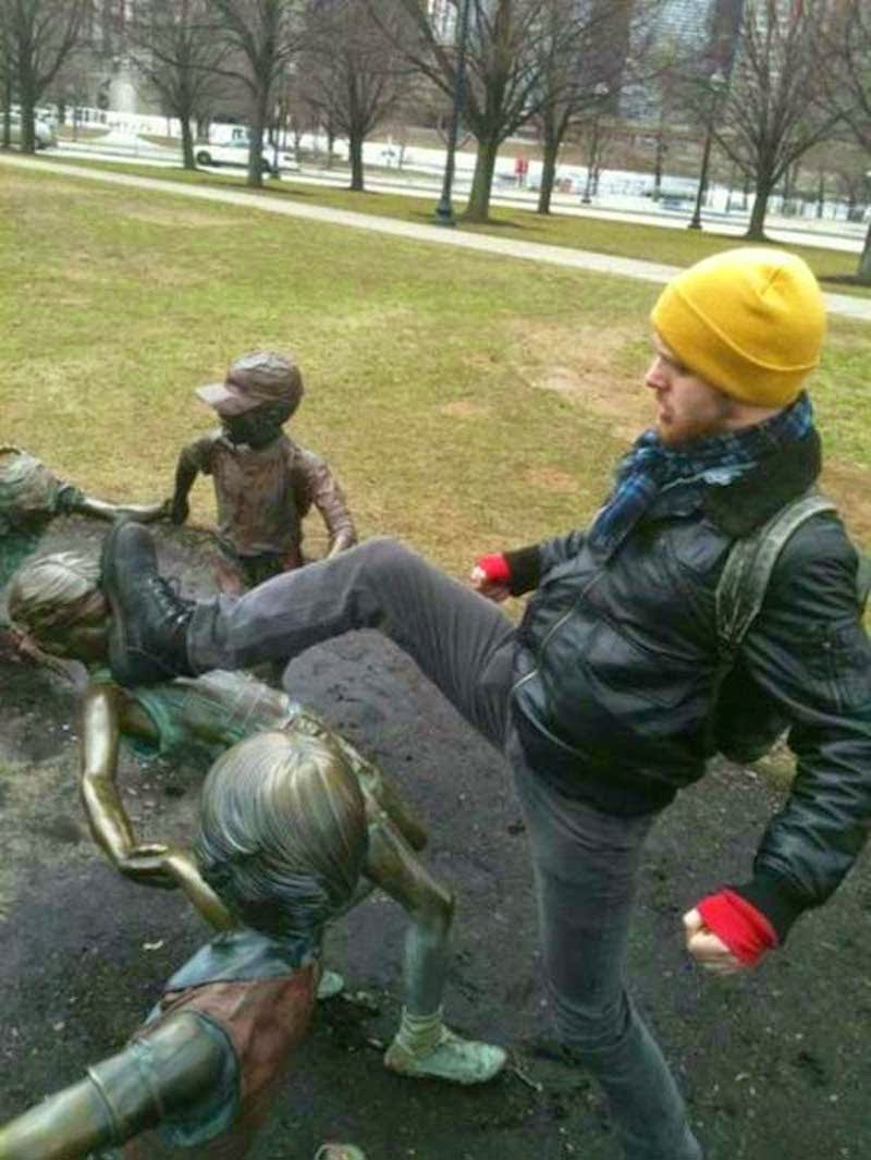 15. Note to the man wearing a yellow beanie: picking on statue children does not make you look tough.  - 23 Times Pedestrians Messed With Statues...And It Was Downright Hilarious