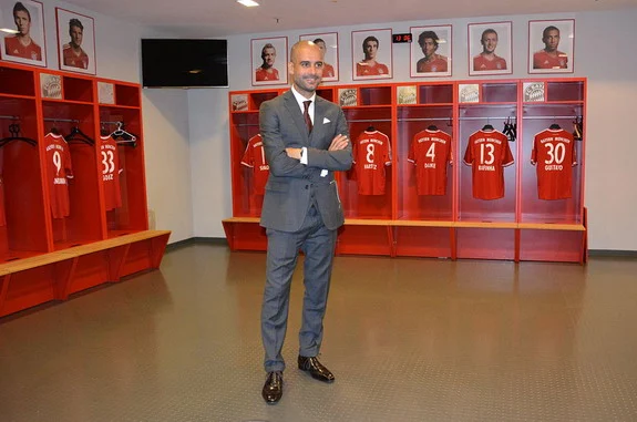 New Bayern Munich coach Pep Guardiola poses in the team locker room inside the Allianz Arena