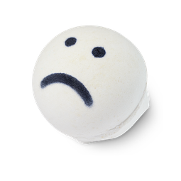 A spherical white bath bomb with a hexagonal bottom with lush engraved into it with a black blue sad face sketched into the top of the bomb on a bright background