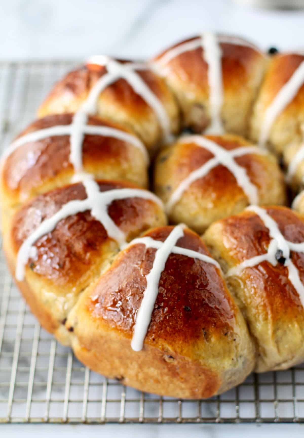 Orange Blueberry Hot Cross Buns on a cooling rack.