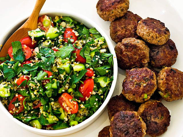 Lamb koftas with tabouli in a serving bowl