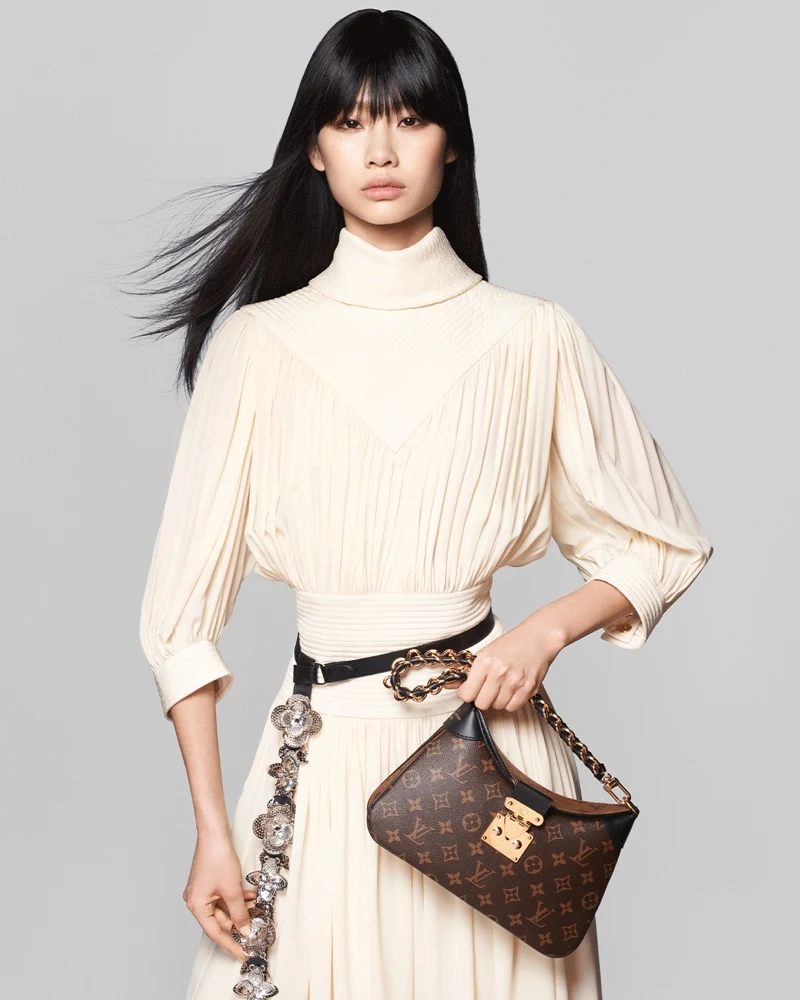 HoYeon Jung embodies elegance in a cream ensemble, paired with a monogram print bag for Louis Vuitton pre-fall