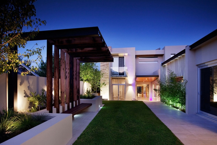 Grass and wooden bench in Modern backyard by Ritz Exterior Design