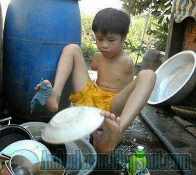 seorang anak kecil sedang mencuci piring