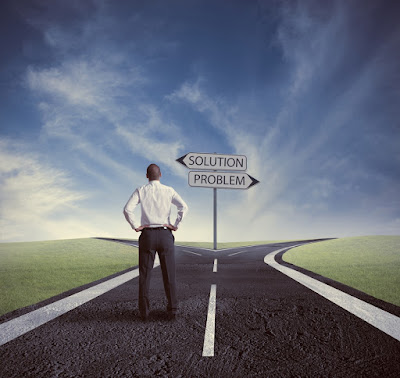 a man is standing at a fork in the road: one sign points to "Solution" and the other sign to "Problem"