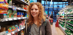 Young woman smiling and shopping in co-op supemarket 