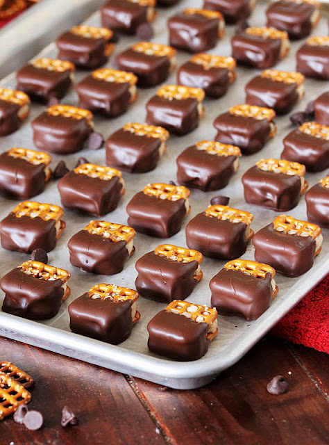 Rows of Chocolate-Dipped Cookie Dough Pretzel Bites on Baking Sheet Image