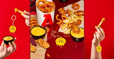 Arby's "Keys to the Cheese" keychains next to regular and curly fries and cups of Cheddar Sauce.