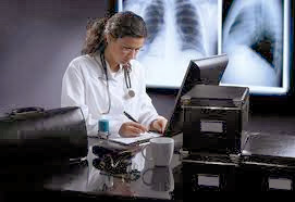 Una doctora rodeada de tecnología en su mesa de trabajo.