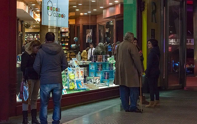 Grupo de gente ferente a una vidriera iluminada