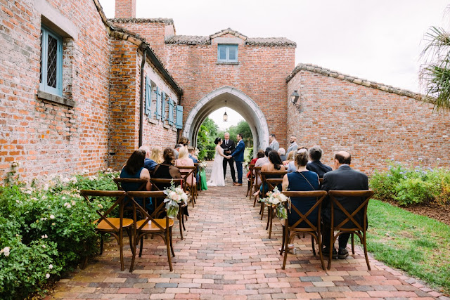 bride and groom getting married at driveway arch at casa feliz