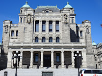 Library side of Victoria BC Parliament Building showing pillared portico and historical and allegorical figures.