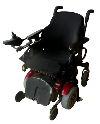 A small electric wheenchair with padded cushions and a roho seat pad.