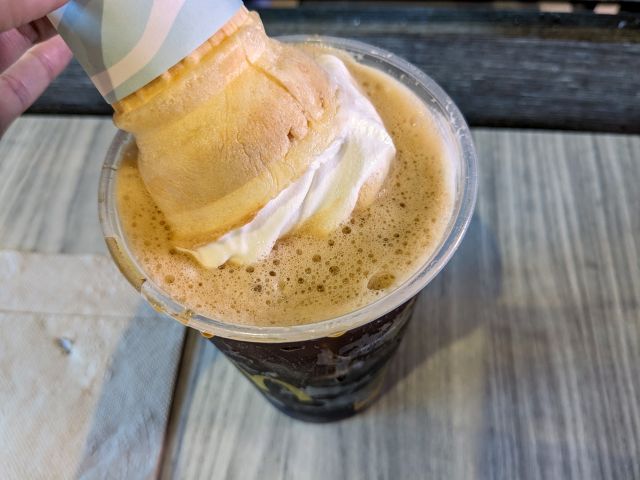 Dunking a McDonald's Vanilla Cone into a cup of iced coffee.