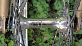 Shiny bicycle hub with background of grass