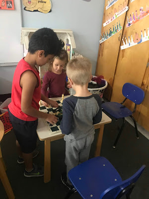 students at table playing chess