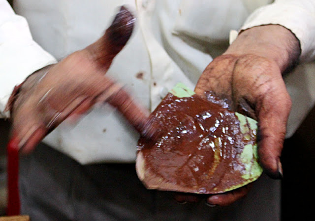 close-up of a man flavouring a paan