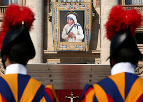 Swiss Guards stand in front of a tapestry depicting Mother Teresa of Calcutta before a mass, celebrated by Pope Francis, for her canonisation in Saint Peter's Square at the Vatican.