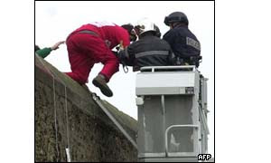 A Basque militant dressed like Santa Claus is taken away by a police officer after climbing on the wall of Sante prison