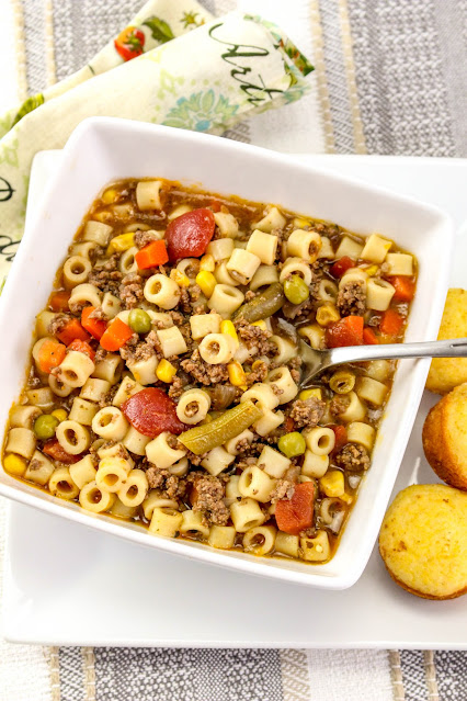 soup in a white bowl with cornbread on the side.