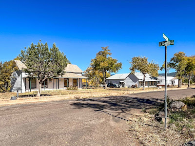 Photograph by the author of the intersection of General Crook Street and Geronimo Street, with 2 white buildings with green accents across the road